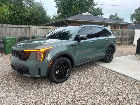 Gray midsize SUV with tinted windows on a gravel drive