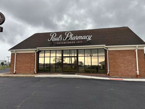 Brick pharmacy building with a wide band of tinted storefront glass