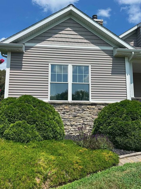 Home picture window with solar film, stone accent below